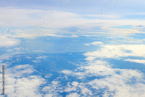 Fototapeta Naklejka Na Ścianę i Meble -  Sun rise in the morning of blue sky above the white clouds and land looking through an airplane window