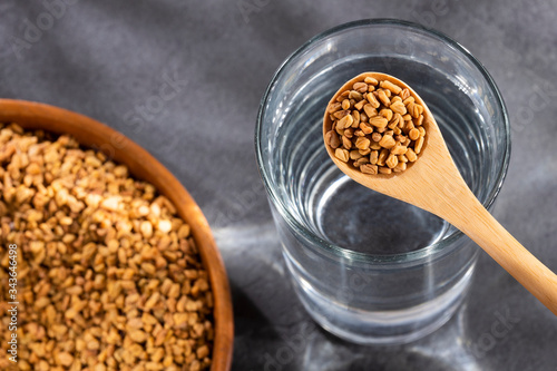 Spoon with fenugreek grains to mix with water - Trigonella foenum-graecum photo