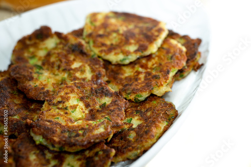 zucchini meal with pumpkin on white plate with yogurt (turkish mucver)