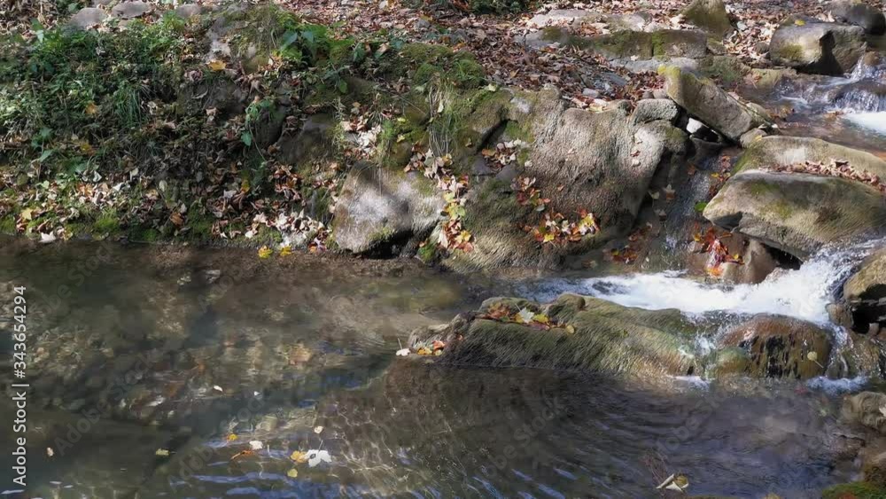 Small waterfall flowing down the mountain stones Small waterfall flowing down the mountain stones