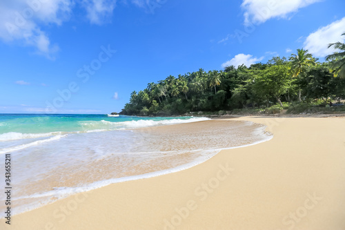 Fototapeta Naklejka Na Ścianę i Meble -  Beach landscape with sand, white foam waves, palm trees, blue sky, turquoise water and clouds, paradise Caribbean coast of Dominican republic 
