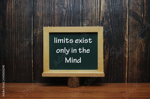Motivational and Creative concept: Blackboard on table with wording " Limits Exist Only In The Mind"