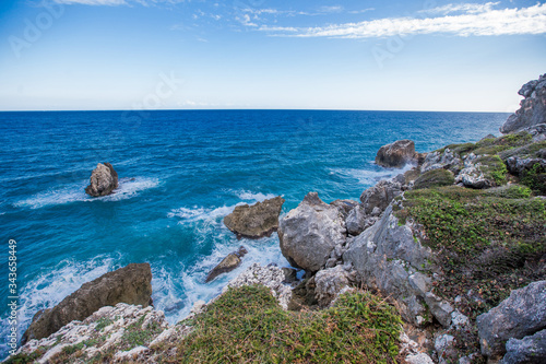 Meadow sea sky cliff landscape at Caribbean coast with green forest rocks and dramatic clouds in Dominican republic