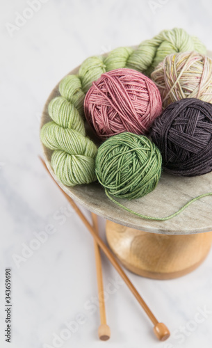 Balls of yarn on stand with knitting needles