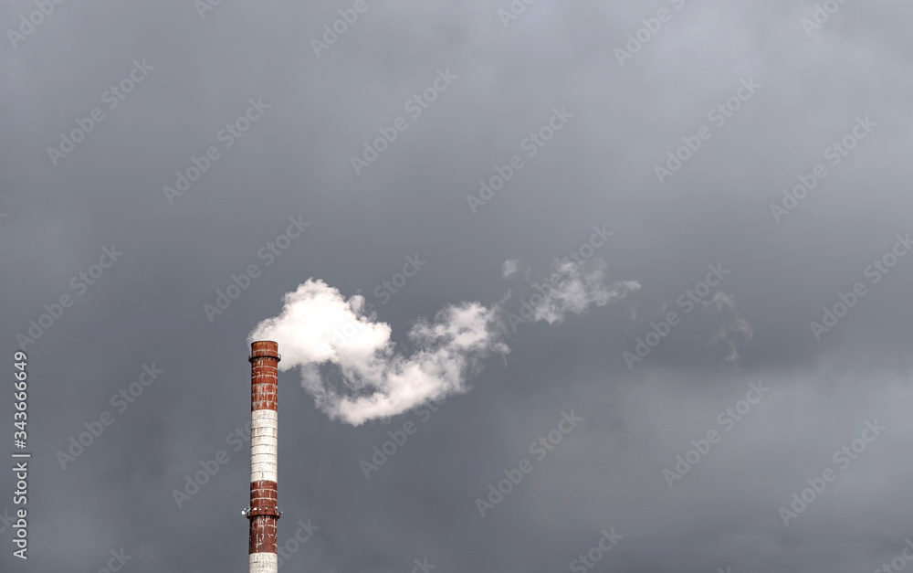 The chimney is isolated against a gloomy sky. Environmental pollution.