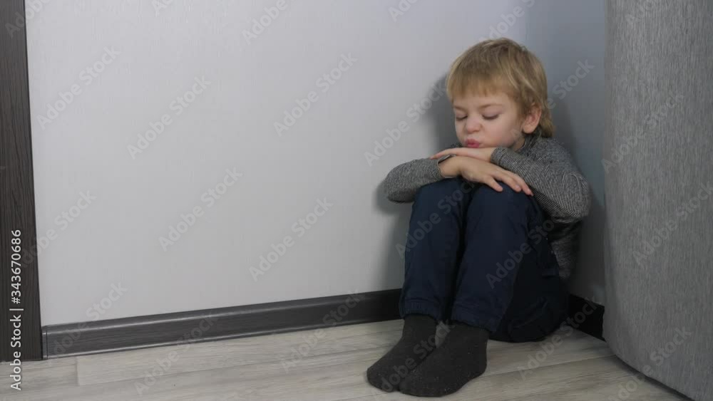 sad upset boy sitting in the corner. Child punished sitting crying in the corner. Domestic violence concept. Child lifestyle abuse sad upset boy sitting in the corner. Child punished sitting crying in the corner. Domestic violence concept. Child lifestyle abuse