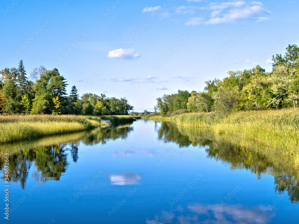 Blue sky reflected in the Mississippi River in Bemidji Minnesota near hiway 2. This scene is a few miles from the source at Lake Itasca with point of view from a boat on the water.