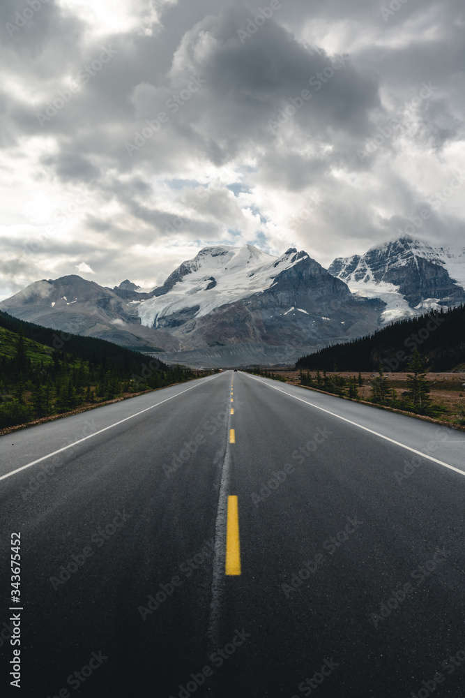 A straight road leading to the mountains during cloudy weather 