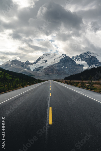 A straight road leading to the mountains during cloudy weather 