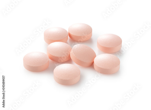Pink pills placed on a white background