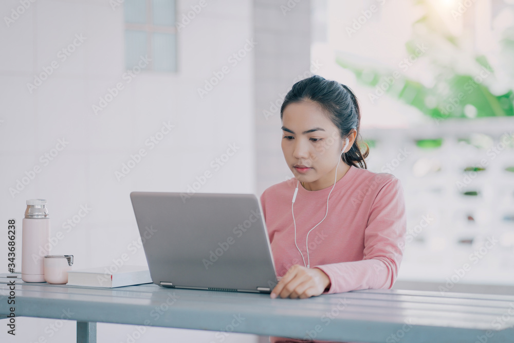 Portrait of a young Asian business woman work with laptop at home in hous corridor and garden during Corona virus or COVID-19 spreading. Work from home concept. Portrait of a young Asian business woman work with laptop at home in hous corridor and garden during Corona virus or COVID-19 spreading. Work from home concept.