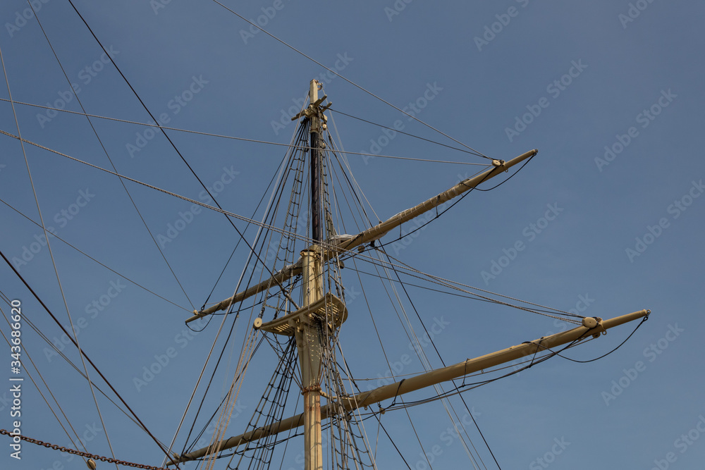 Mast of an old sailing vessel, rigging lines with block and tackle, horizontal aspect Mast of an old sailing vessel, rigging lines with block and tackle, horizontal aspect