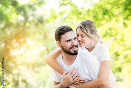 Happy young caucasian couple embracing together with passionate love in public park,Couple in love hugging and having romantic tender moments in the summer vacation.Lifestyle loving couple at nature.