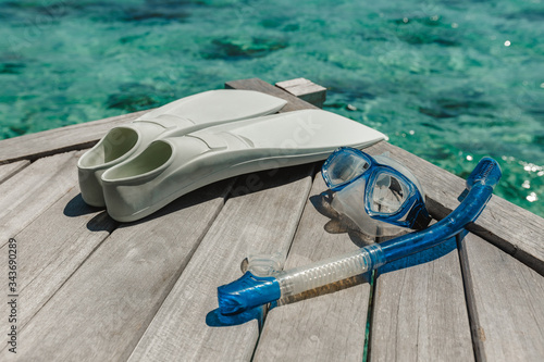 Snorkelling equipment on wood background. Flippers, mask and snorkel top view image. diver eyeglasses, diving goggles, snorkel and fins on the jetty