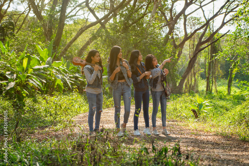 Group of Asian teenage girl being happy with hiking and studying nature. They spend their free time during the summer vacation camping in the forest. #343691805