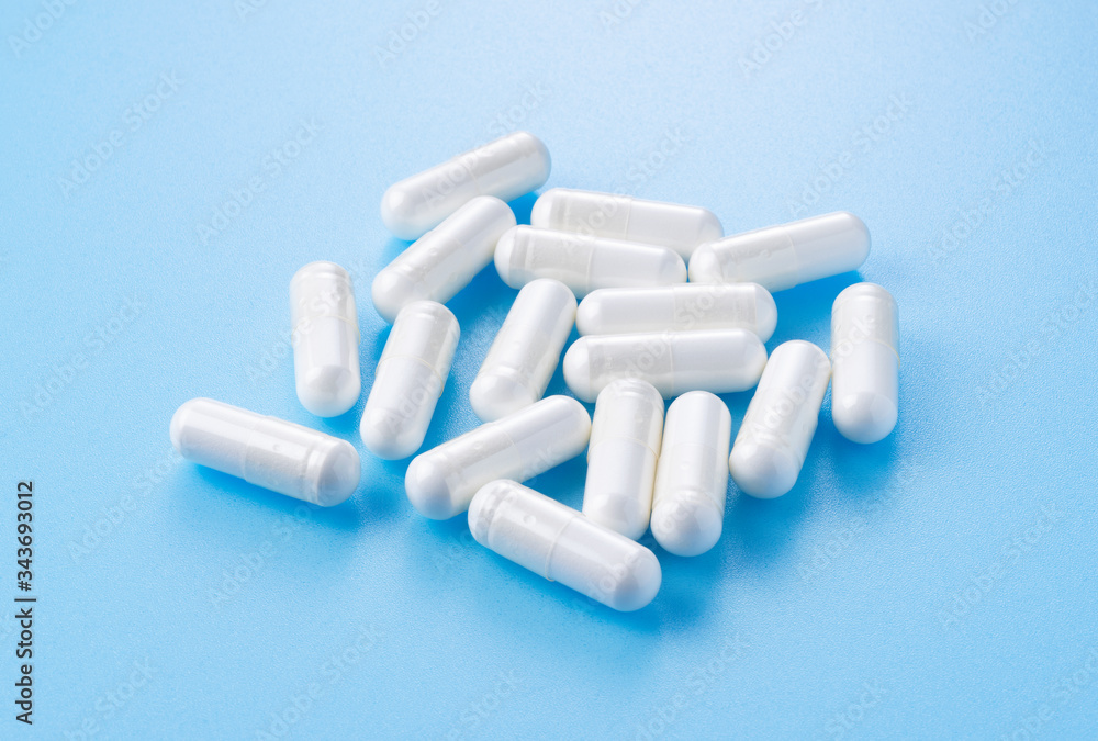 White capsules placed on blue background White capsules placed on blue background
