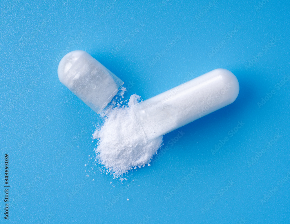 White capsules placed on blue background White capsules placed on blue background