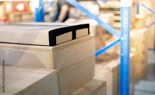 A pile of cardboard box parcel prepare to put on the shelf or blue metal rack