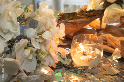 Mesa de evento diurno decorada con vela y flores blancas