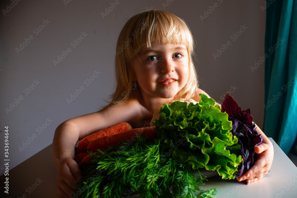 Little girl smiles and hugs vegetables with her hands. Selective focus. Little girl smiles and hugs vegetables with her hands. Selective focus.