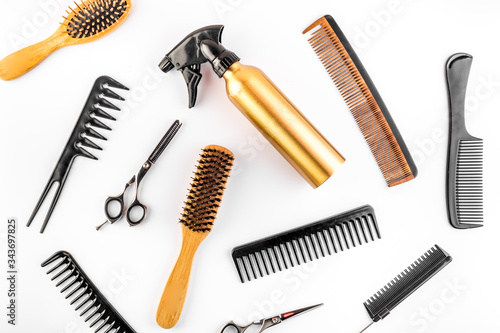 Hairdresser set in beauty salon. Combs, sciccors, spray on white desk top-down