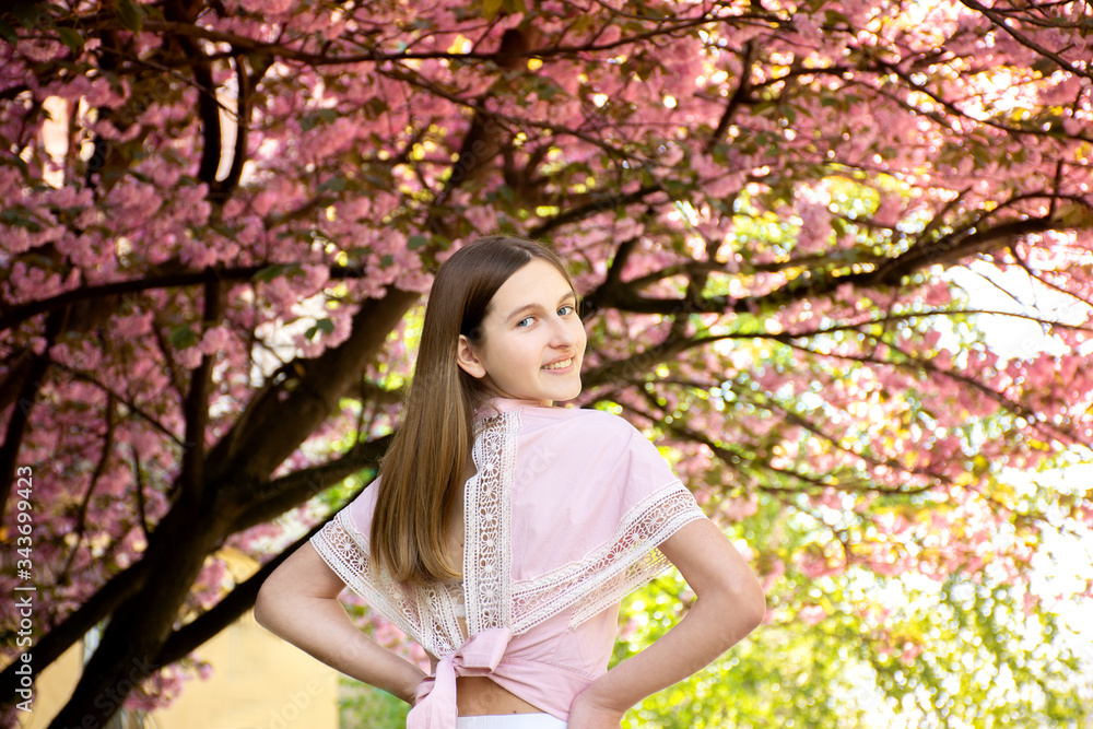 Portrait of a beautiful teenage girl in delicate sakura flowers Portrait of a beautiful teenage girl in delicate sakura flowers