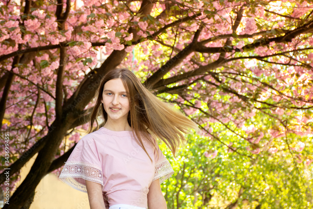 Portrait of a beautiful teenage girl in delicate sakura flowers Portrait of a beautiful teenage girl in delicate sakura flowers