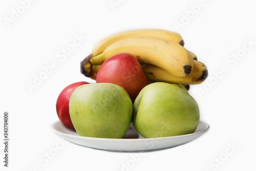 fruit apples and bananas on a white plate