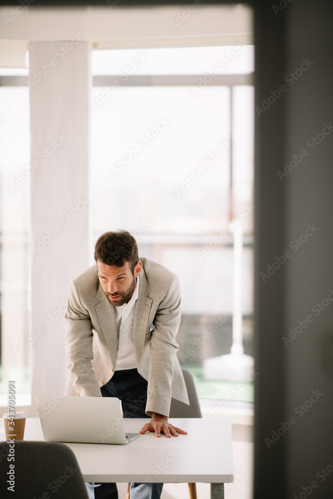 Young businessman working in office. Handsome man preparing for the meeting.	