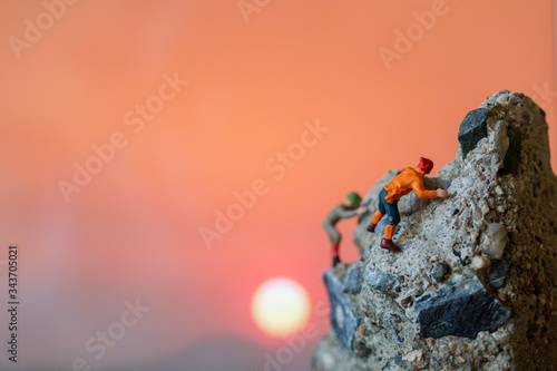 Miniature people: Hikers climbing up on the rock . Sport and leisure concept. © Sirichai Puangsuwan
