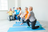 Elderly people exercising in gym