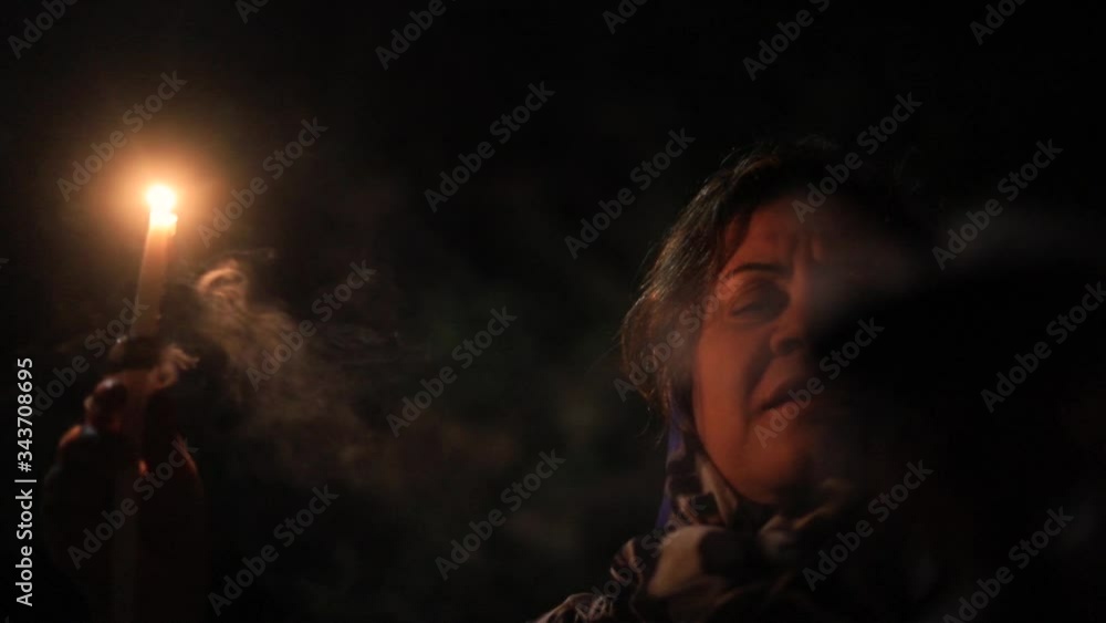 young women holding a candle praying with incense smoke, closeup young women holding a candle praying with incense smoke, closeup