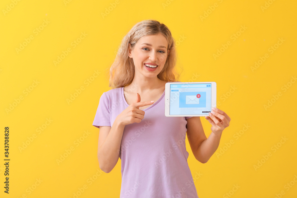 Young woman with tablet computer checking her e-mail on color background Young woman with tablet computer checking her e-mail on color background