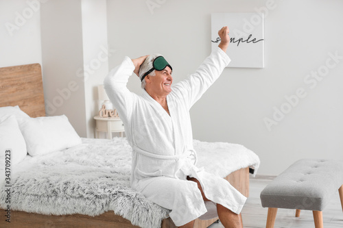 Morning of happy mature man in bedroom