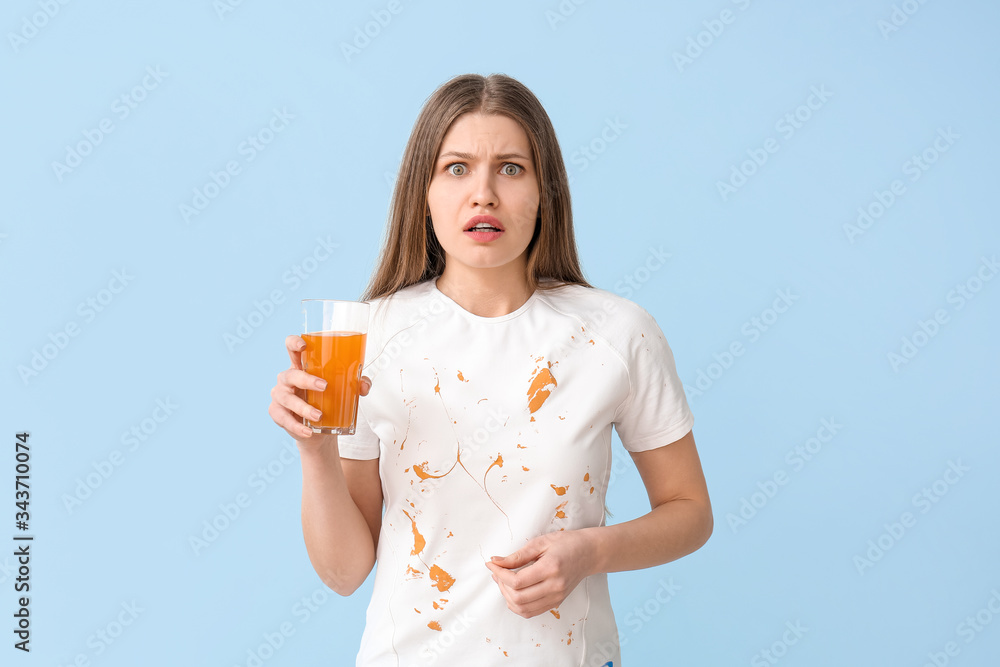 Troubled woman in dirty clothes drinking juice on color background Troubled woman in dirty clothes drinking juice on color background