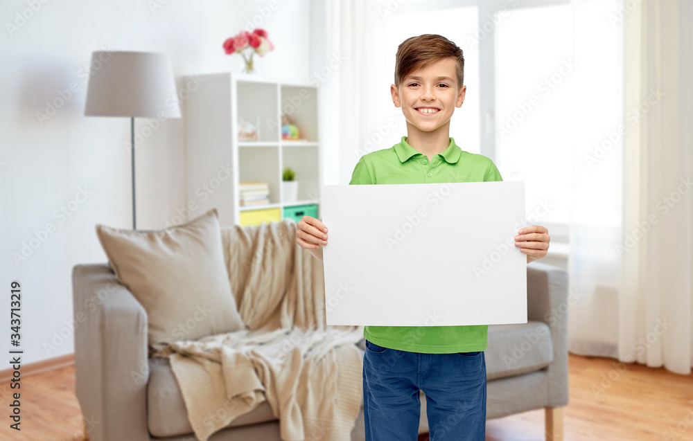 childhood, advertisement and people concept - happy smiling boy in green polo t-shirt holding white blank paper sheet at home childhood, advertisement and people concept - happy smiling boy in green polo t-shirt holding white blank paper sheet at home