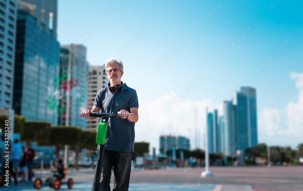 Senior using electric scooter for transportation in a modern city Senior using electric scooter for transportation in a modern city