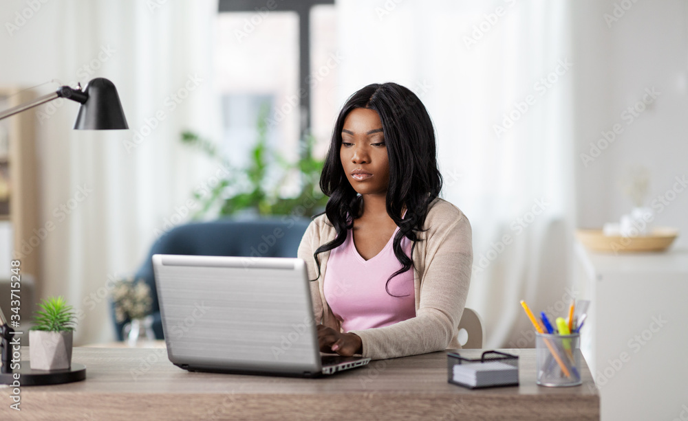 remote job, technology and people concept - african american young woman with laptop computer working at home office remote job, technology and people concept - african american young woman with laptop computer working at home office