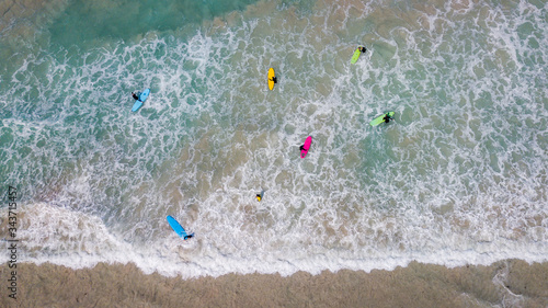 Obraz na plátně Areal shot of surfers with colourful surfboards surfing the white water