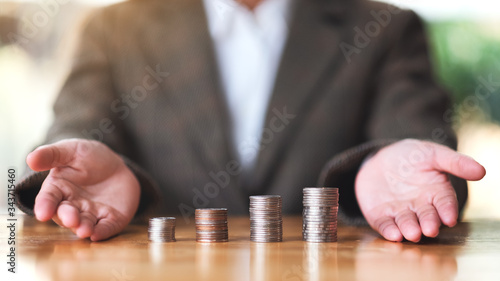 Businesswoman showing stack of coins on the table for saving money concept