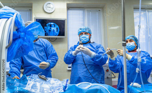 Surgery operation. Group of surgeons in operating room with surgery equipment. Medical background, selective focus