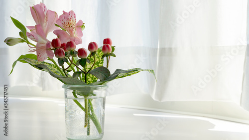 A small spring bouquet. Pink alstroemeria, red hipericum and gold dust dracaena. photo