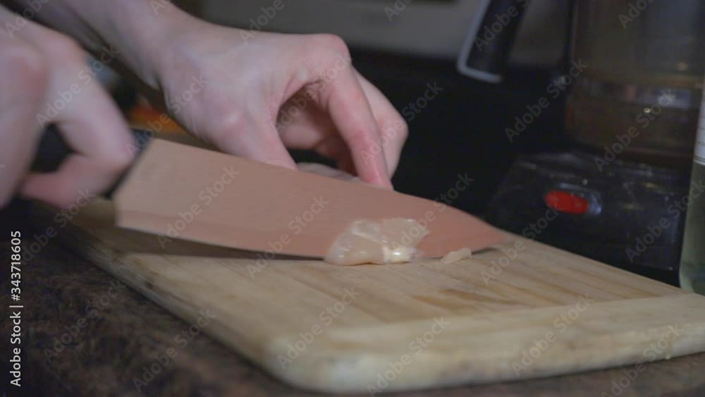 A Person Cutting Chicken Meat Into Pieces On The Wooden Board - Close Up Shot A Person Cutting Chicken Meat Into Pieces On The Wooden Board - Close Up Shot