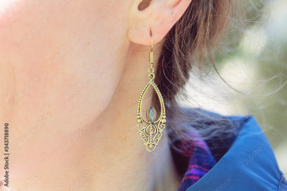 Outdoor detail of female ear wearing beautiful elegant earring