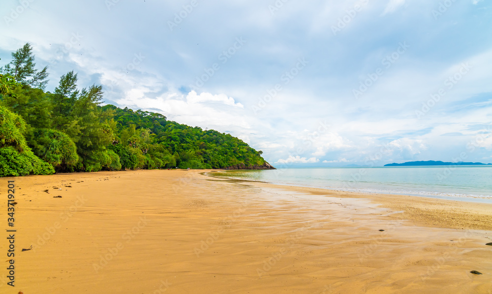 View of beach at Mu Ko Lanta national park, Thailand. Beach near fresh green jungle, warm sand and pure blue water. Cloudy weather, summer day. Famous travelers destination.