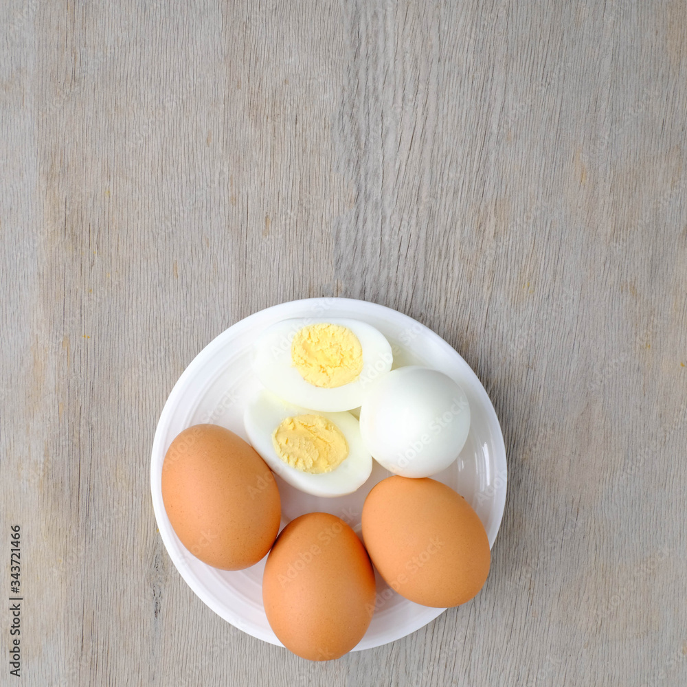 halves of boiled and raw chicken eggs on wooden rustic background. the view from the top
halves of boiled and raw chicken eggs on wooden rustic background. the view from the top