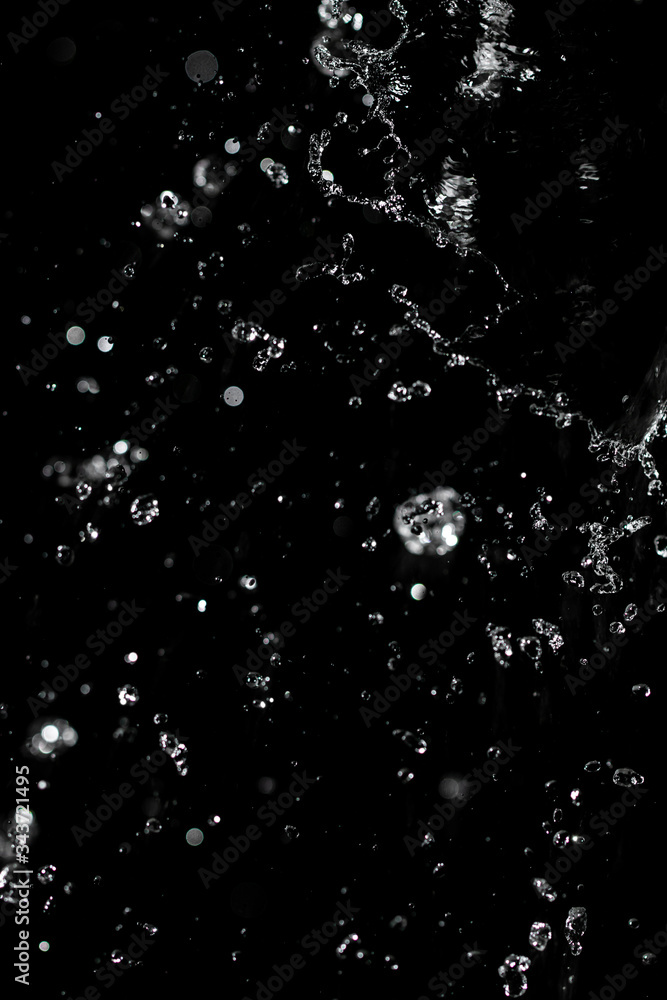 jet of water with splashes on a black background jet of water with splashes on a black background