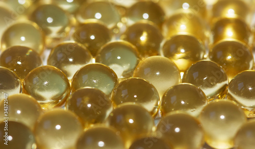 Yellow fish oil in capsules background. Omega3 vitamins close-up. Capsules fish oil macro. Vitamins for health.
