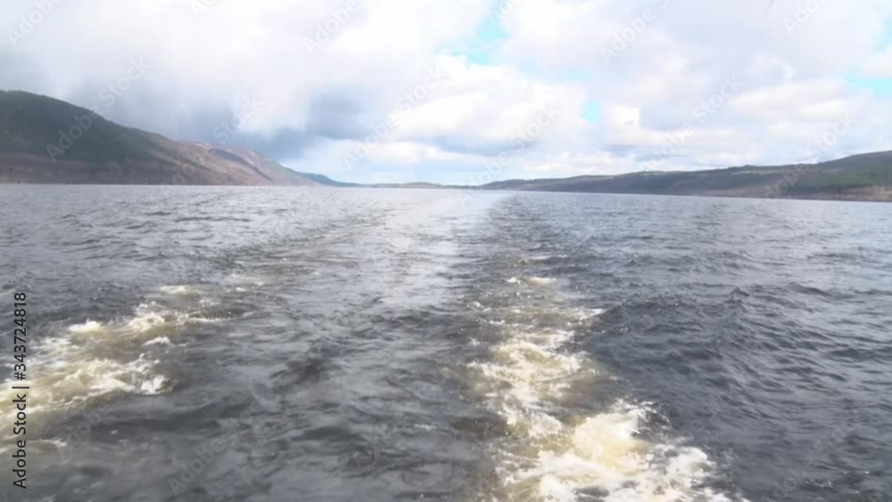 Loch Ness filmed handheld from the back a moving boat. One can see the trails of the boat in the water. Loch Ness filmed handheld from the back a moving boat. One can see the trails of the boat in the water.