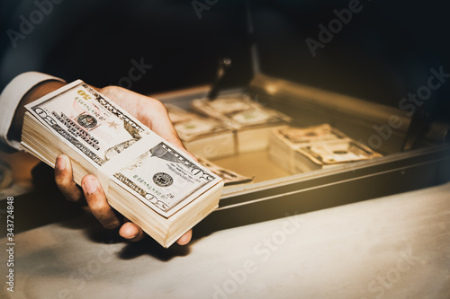 Corruption concept : Hand of a badly-influenced business man holds a dollar for a career in corruption. Money from corruption is used as a proposal to deprive justice.